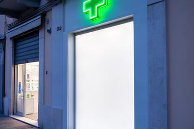 Farmacia di Loano con croce luminosa verde e insegna leggibile dalla strada