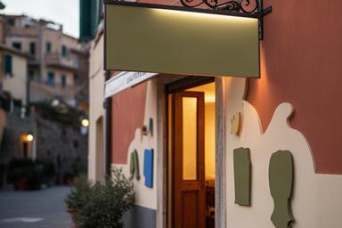 Ristorante di Borgio Verezzi con insegna a bandiera e lettere decorative sulla facciata
