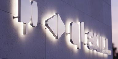 Lettere tridimensionali retroilluminate montate su una parete esterna di uno studio professionale
