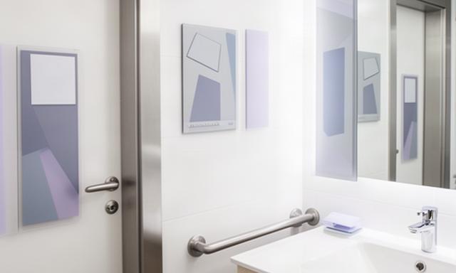 Segnaletica identificativa e indicazioni di sicurezza in un bagno luminoso di una struttura ricettiva